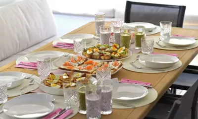 Adriatic Tiger: Mesa de madeira posta para o café da manhã com sanduíches abertos, vitaminas e taças de cristal