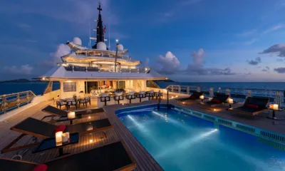Alfa Nero: Piscina do deck iluminada com espreguiçadeiras e velas ao anoitecer, com a superestrutura atrás
