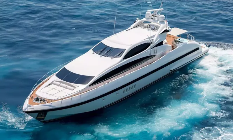 Allure: Iate a motor branco navegando em mar azul profundo visto de cima, com a esteira atrás
