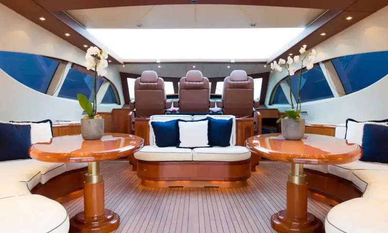 Allure: Lounge superior com mesas de madeira brilhante, sofás brancos e assentos do leme sob uma claraboia