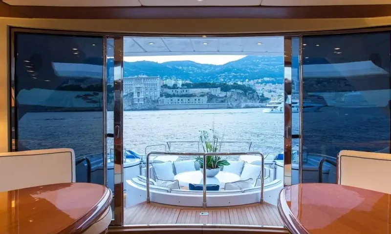 Allure: Vista do interior através das portas de vidro abertas para os assentos do convés de popa e a cidade na colina