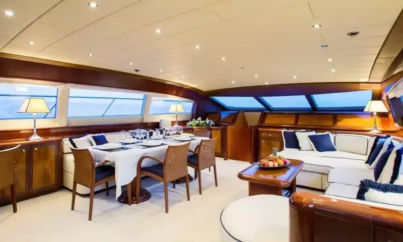 Allure: Salão principal com mesa de jantar posta, cadeiras de madeira e sofás brancos