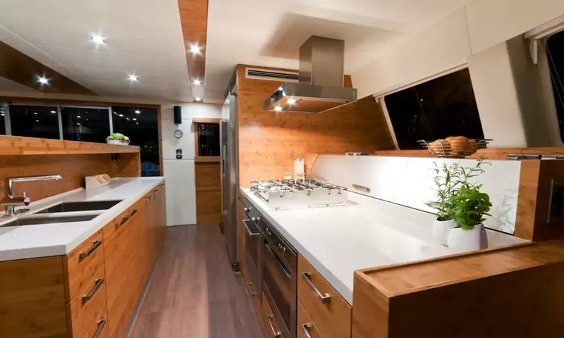 Anini: Wooden galley with white counters, double sink, gas hob, ovens and a range hood
