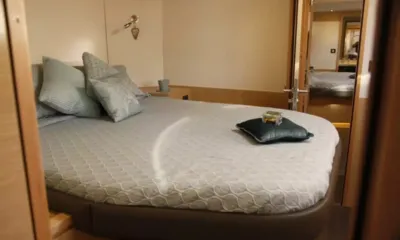 Aoibh: Cabin with a large double bed, grey patterned cover and blue cushions