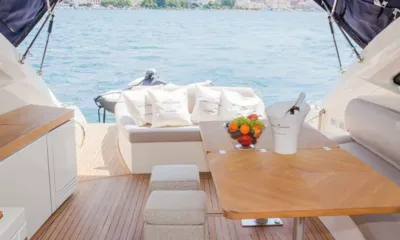 Atlantis 5: Mesa do cockpit com frutas e balde de champanhe diante de um sofá de popa e vista para o mar