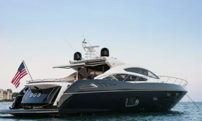 BG3: Motor yacht at anchor seen from the stern quarter with flag flying