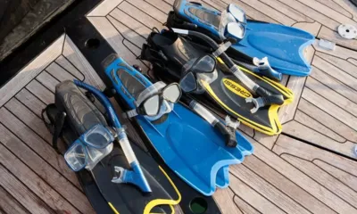 BG3: Masks, snorkels and fins laid out on a teak deck