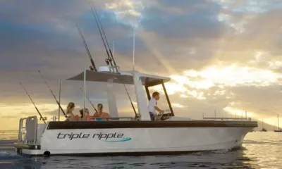 Big Fish: Bote auxiliar com varas de pesca levando hóspedes pela água ao pôr do sol