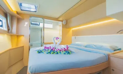 Blue Moon: Double bed with towel swans and orchids in a cabin with soft lighting and hatch