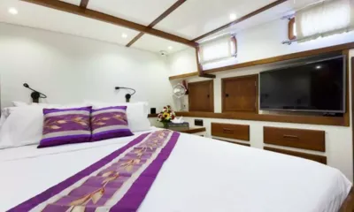 Dallinghoo: Cabine dupla com roupa de cama branca, trilho e almofadas roxos, TV de parede e gavetas de madeira