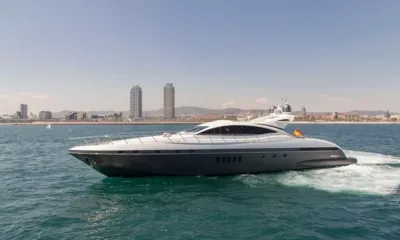 Five Stars: Yacht a motore in navigazione su acqua turchese con lo skyline di una città e torri gemelle alle spalle