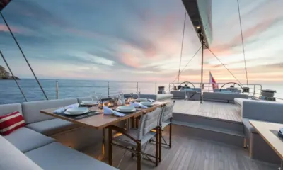 G2: Mesa posta para o jantar no convés ao pôr do sol, postos de comando e mar ao fundo