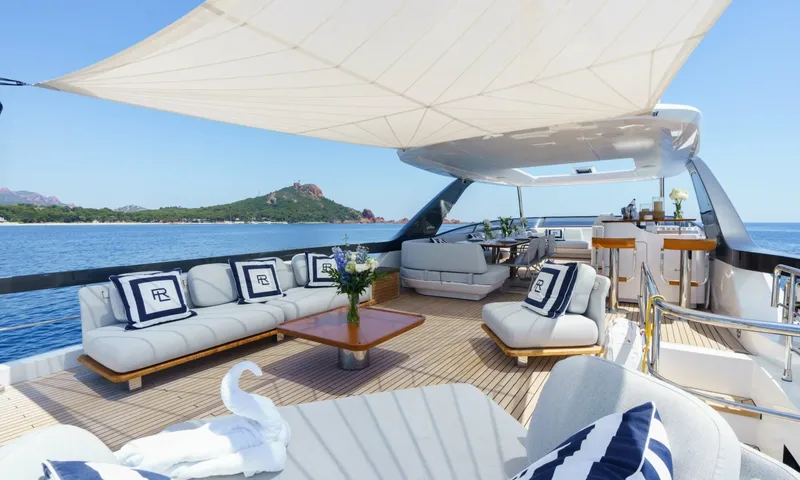 Getaway: Shaded top deck with sofas, coffee table and bar stools overlooking a green headland
