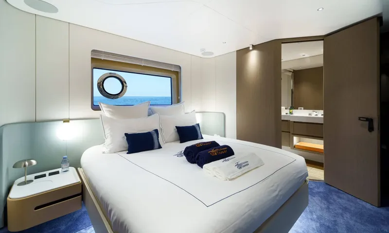 Getaway: Double cabin with navy cushions, a porthole window and an open door to the ensuite