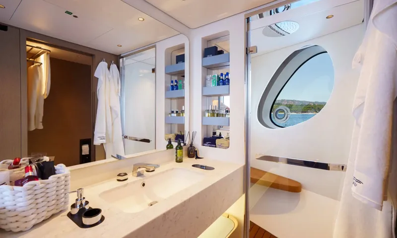 Getaway: Ensuite with stone basin, toiletry shelves, bathrobes and a glass shower with oval window