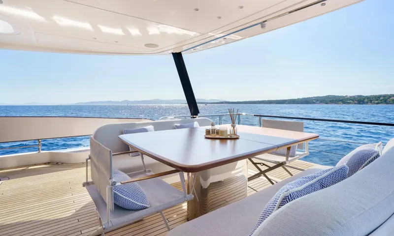 Getaway: Shaded deck with a table, folding chairs and cushioned seating facing open sea