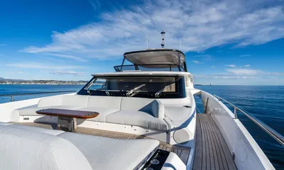 Getaway: Foredeck lounge with grey cushions and a small table facing the windscreen under blue sky