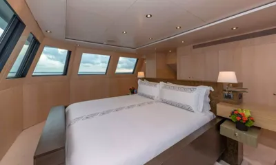 Highlander: Cabine com cama de casal, abajures de cabeceira e janelas inclinadas com vista para o mar