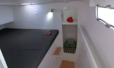 Hot Chilli: Cabine compacta com colchão grande cinza, flores, luminárias de parede e prateleira de armazenamento