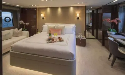 Hot Pursuit: Large cabin with double bed, sofa, desk and hull window, a tray with drinks on the bed