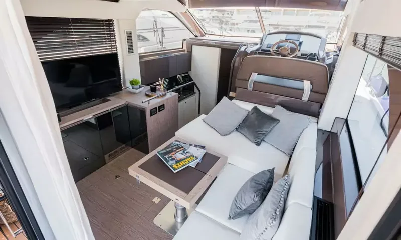 Jupika II: Vue en hauteur du salon avec canapé blanc, table basse, télévision et poste de pilotage inférieur