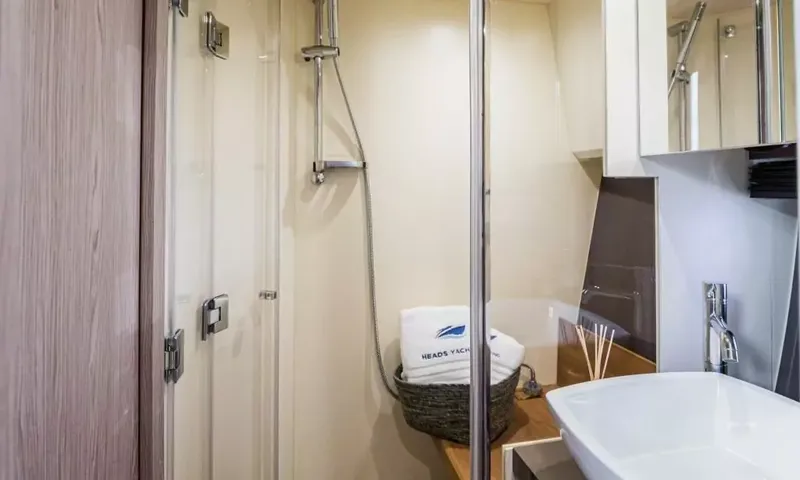 Jupika II: Cabine de douche avec porte en verre, douchette, panier à serviettes et lavabo