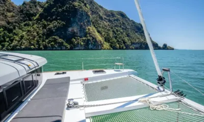 K35: Convés de proa com redes trampolim e área lounge acolchoada voltada para um penhasco arborizado