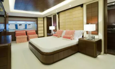 Koukles: Cabine espaçosa com cama de casal, almofadas coral, abajures de cabeceira e duas poltronas junto à janela