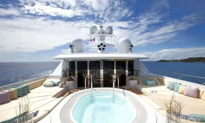 Lady Britt: Jacuzzi do deck superior entre espreguiçadeiras acolchoadas sob um céu claro e nublado