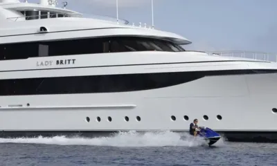 Lady Britt: Piloto em um jet ski passando em alta velocidade pelo casco branco de um grande iate