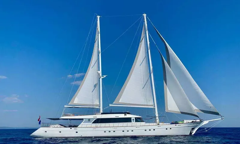 Lady Gita: Voilier blanc à deux mâts toutes voiles dehors sur une mer bleu profond