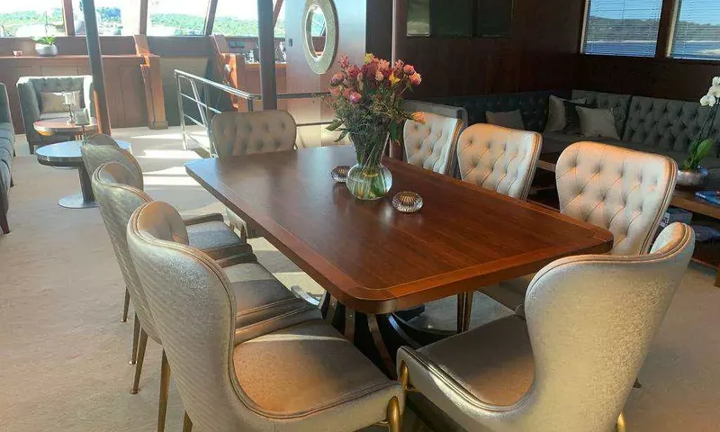 Lady Gita: Table à manger en bois à l'intérieur avec chaises capitonnées et fleurs