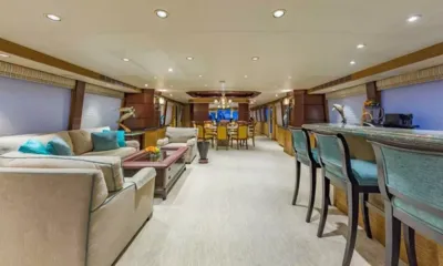 Legendary: Salão longo com sofás bege, um bar com banquetas e uma mesa de jantar ao fundo