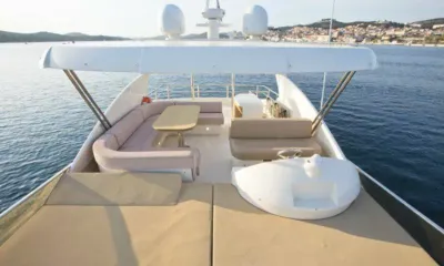 Malibu: Flybridge com colchonetes de sol, sofá curvo, mesa e leme sob um hardtop