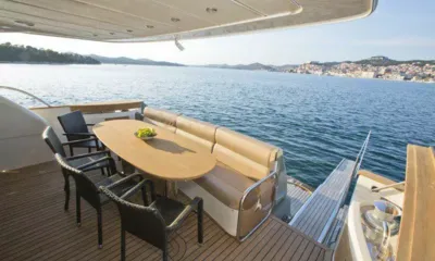 Malibu: Mesa de jantar do deck de popa com cadeiras de vime com vista para o mar e uma cidade na encosta