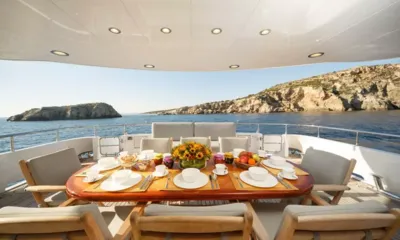 Milos at Sea: 果物と花を飾った屋外ダイニングテーブル、岩の島々と海を望む