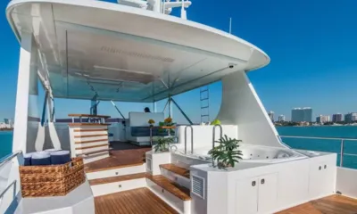 Moni: Deck superior com jacuzzi, plantas, degraus e uma área de bar sombreada sob um hardtop