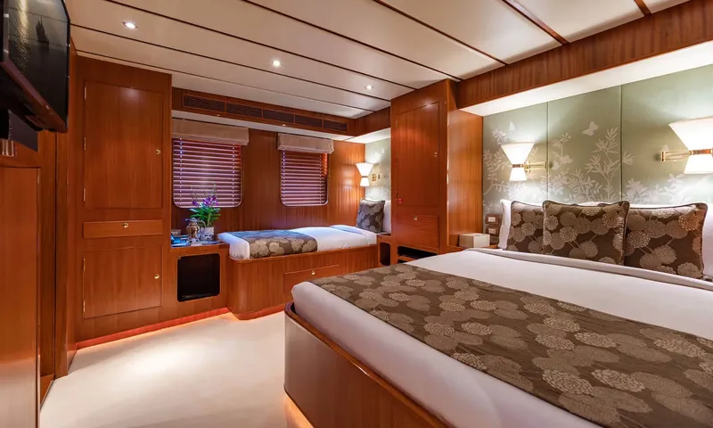 Northern Sun: Cabin with a double bed, a single bed beneath windows and wooden cupboards
