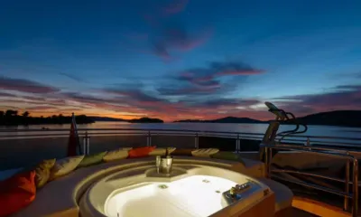 Novela: 島々を望む夕日の中、最上階デッキにあるカラフルなクッション付きの明かりの灯るジャグジー