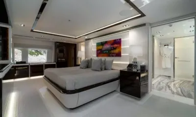 O'Mathilde: Cabine ampla com cama de casal cinza, abajures, obra de arte colorida e banheiro privativo aberto com piso de mármore