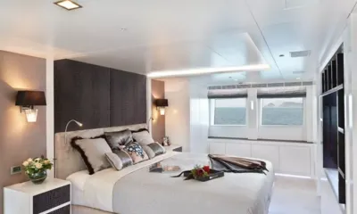 Ocean's Seven: Large double cabin with dark headboard, wall lamps and windows looking out to sea