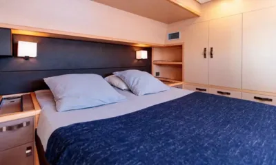 Oryxa: Doppelkabine mit blauer Tagesdecke, Leselampen und Kleiderschränken aus hellem Holz