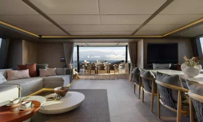 Otoctone: Saloon with sofa and dining table opening onto an aft deck dining area and the sea