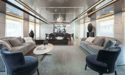 Petratara: Lounge principal com sofás cinza, poltronas azuis e área de jantar ao fundo
