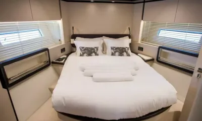 Prewi II: Cabine com cama de casal central, travesseiros estampados, toalhas enroladas e janelas dos dois lados