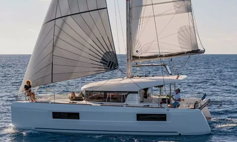 Grande: Catamaran sailing with both sails up and guests relaxing on deck and at the helm