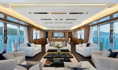 Settlement: Bright saloon with white sofas, black coffee table and large windows on both sides