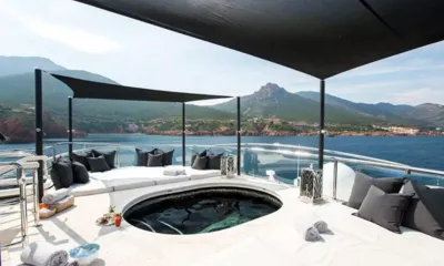 Silver Angel: Jacuzzi redondo cercado por colchonetes de sol almofadados sob toldos pretos, com montanhas ao fundo