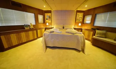 Simay F: Wide cabin with central double bed, wooden cabinets, paintings and windows on both sides