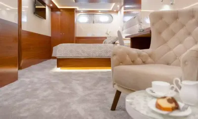 Son De Mar: Cabine espaçosa com cama, poltrona capitonê, painéis de madeira e café com bolo em uma mesa lateral